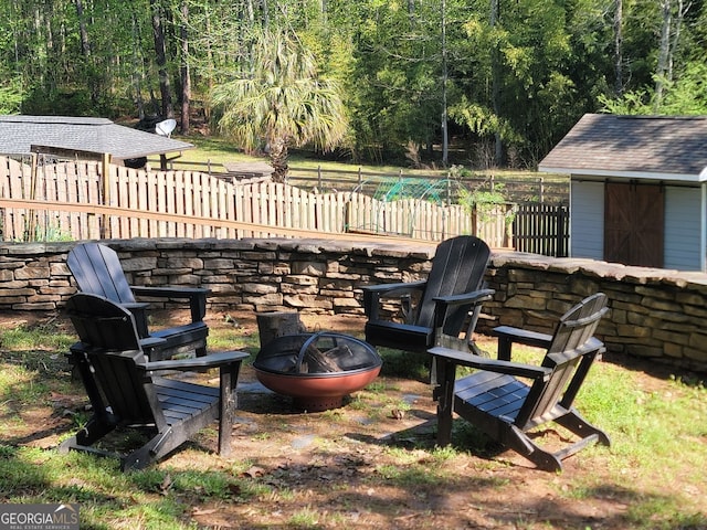 60 Bartlett Way, Dallas, GA 30157 - view of yard with a fire pit, fence, an outdoor structure, a storage shed, and a view of trees