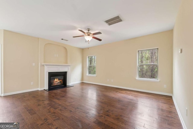 3892 Trillium Wood Trl, Snellville, GA 30039 - unfurnished living room with healthy amount of natural light, ceiling fan, a glass covered fireplace, and wood finished floors