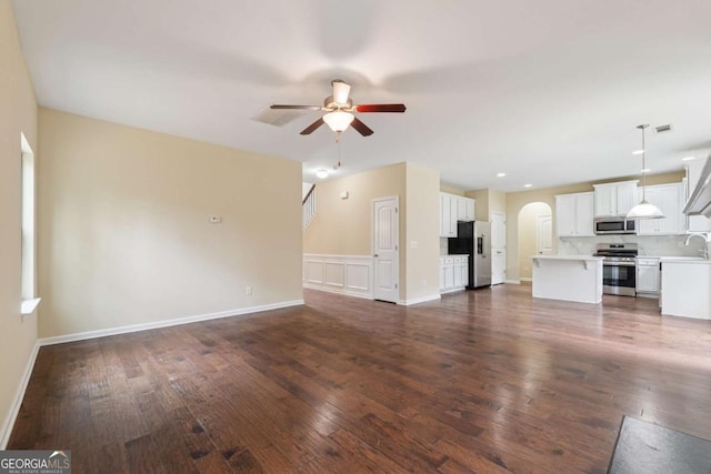 3892 Trillium Wood Trl, Snellville, GA 30039 - unfurnished living room featuring arched walkways, a ceiling fan, and dark wood-style floors