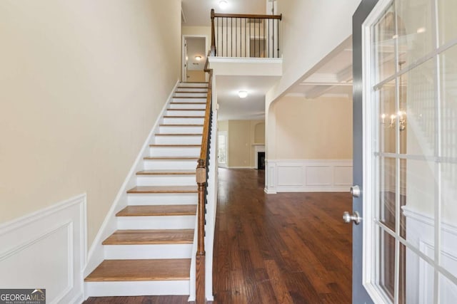 3892 Trillium Wood Trl, Snellville, GA 30039 - stairway with a decorative wall, wood finished floors, a towering ceiling, and wainscoting