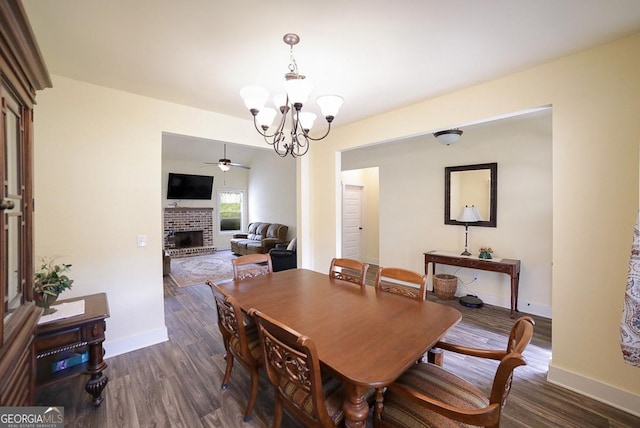 393 Old Good Hope Rd, Good Hope, GA 30641 - dining room with dark wood-style floors, ceiling fan with notable chandelier, baseboards, and a brick fireplace