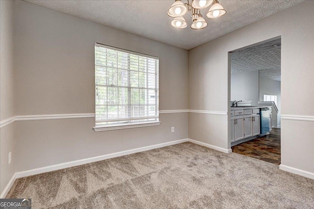 3612 River Mill Ct, Ellenwood, GA 30294 - carpeted spare room with a textured ceiling, an inviting chandelier, baseboards, and a sink
