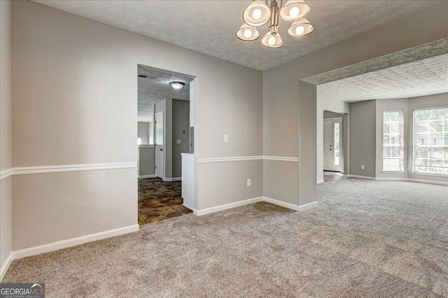 3612 River Mill Ct, Ellenwood, GA 30294 - empty room with a chandelier, baseboards, carpet, and a textured ceiling