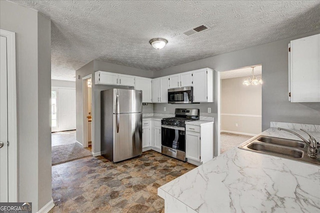 3612 River Mill Ct, Ellenwood, GA 30294 - kitchen with visible vents, a notable chandelier, a sink, appliances with stainless steel finishes, and white cabinetry