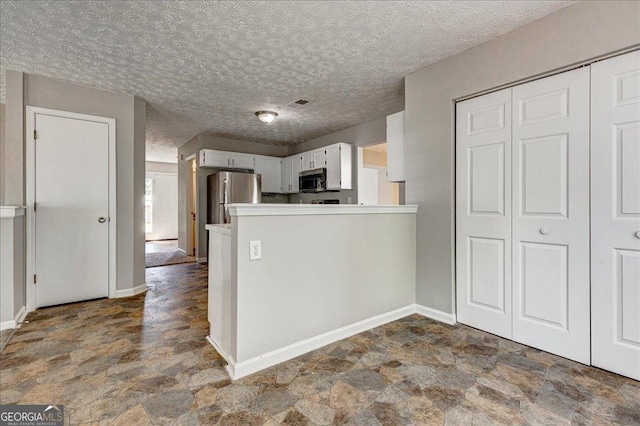 3612 River Mill Ct, Ellenwood, GA 30294 - kitchen with baseboards, stone finish floor, a peninsula, and stainless steel appliances