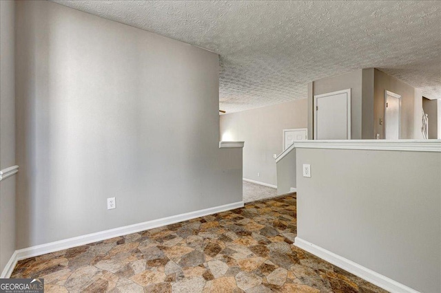 3612 River Mill Ct, Ellenwood, GA 30294 - unfurnished room with stone finish flooring, baseboards, and a textured ceiling