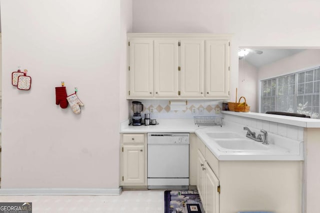 kitchen with tasteful backsplash, white cabinetry, light countertops, a sink, and white dishwasher