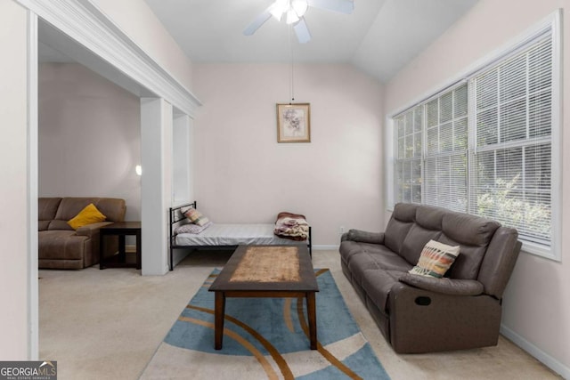 living room with baseboards, vaulted ceiling, light colored carpet, and a ceiling fan