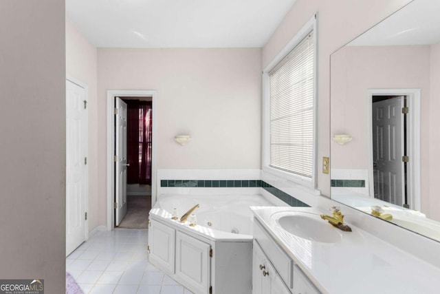 full bathroom featuring a jetted tub, vanity, and tile patterned flooring