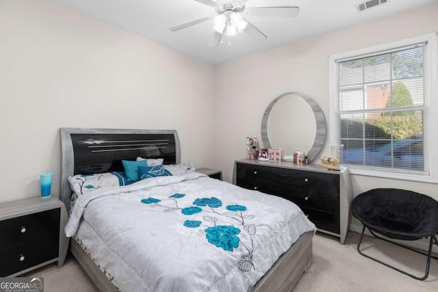 bedroom featuring light carpet, visible vents, and ceiling fan