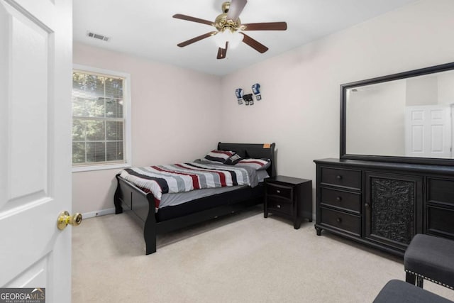 bedroom featuring visible vents, baseboards, a ceiling fan, and light colored carpet