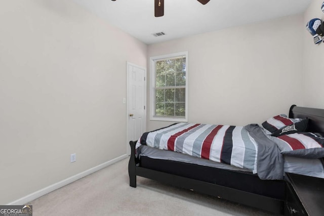 carpeted bedroom with baseboards, a ceiling fan, and visible vents