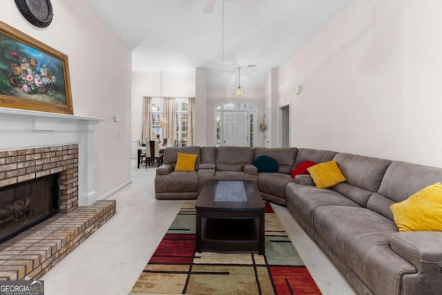 living area featuring a ceiling fan and a brick fireplace