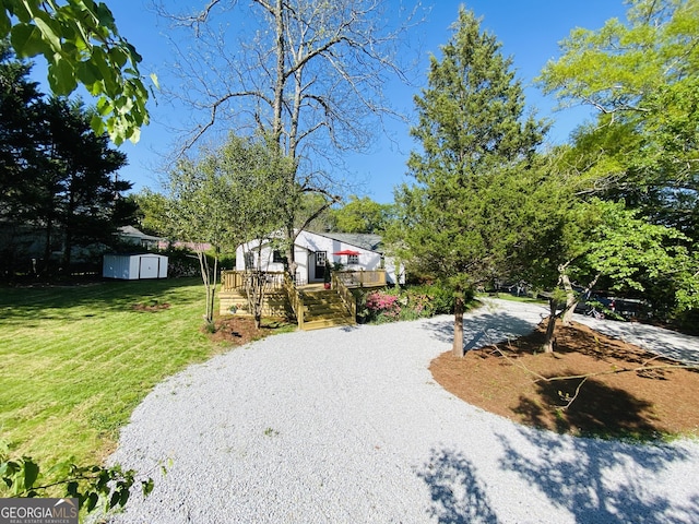 exterior space with a deck, an outbuilding, and a storage unit