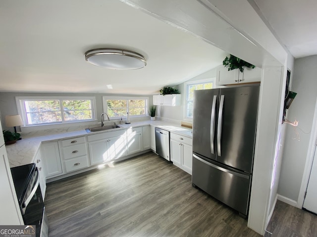 kitchen with a sink, light countertops, stainless steel appliances, vaulted ceiling, and dark wood-style floors