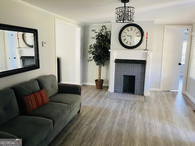 living room featuring baseboards, ornamental molding, wood finished floors, and a fireplace