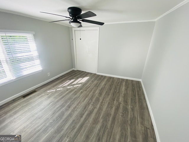 unfurnished bedroom with baseboards, ornamental molding, wood finished floors, and visible vents