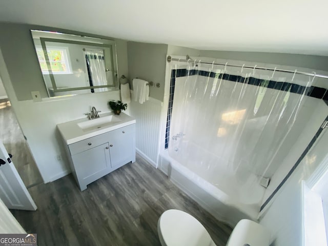 bathroom featuring toilet, wood finished floors, shower / tub combo with curtain, and vanity