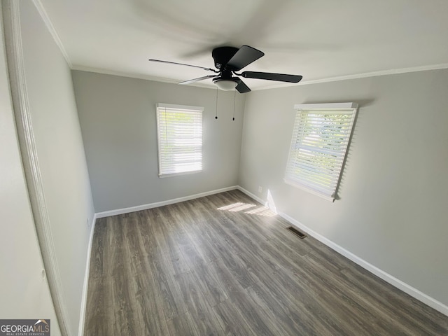 spare room with plenty of natural light, ornamental molding, dark wood-style floors, and ceiling fan