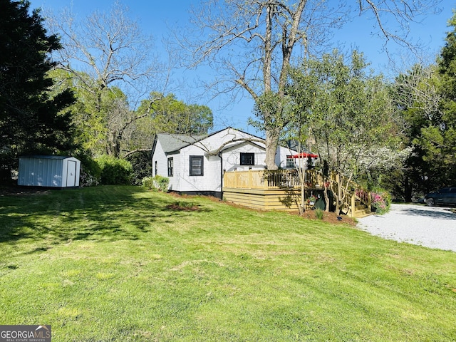 view of yard with an outbuilding, a deck, and a shed