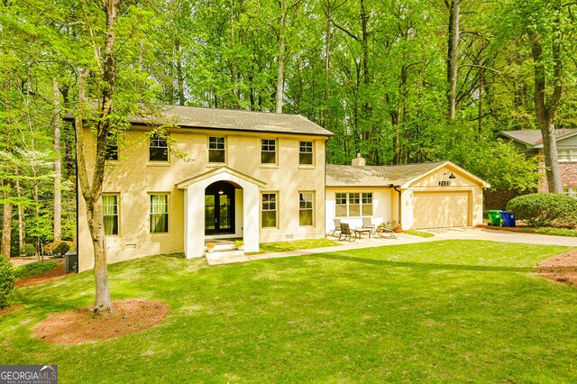 2433 Helmsdale Dr NE, Atlanta, GA 30345 - colonial home featuring concrete driveway, a chimney, a front yard, brick siding, and a garage