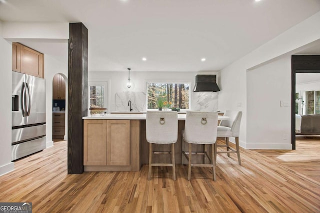 2433 Helmsdale Dr NE, Atlanta, GA 30345 - kitchen featuring light wood-style floors, stainless steel fridge with ice dispenser, arched walkways, ventilation hood, and light countertops