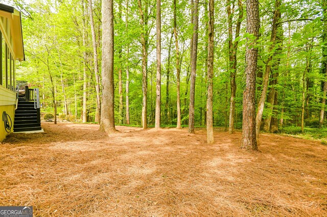 2433 Helmsdale Dr NE, Atlanta, GA 30345 - view of yard featuring a wooded view and stairs
