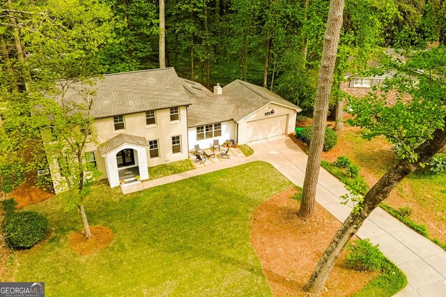 2433 Helmsdale Dr NE, Atlanta, GA 30345 - colonial inspired home featuring a garage, stucco siding, a front lawn, driveway, and roof with shingles