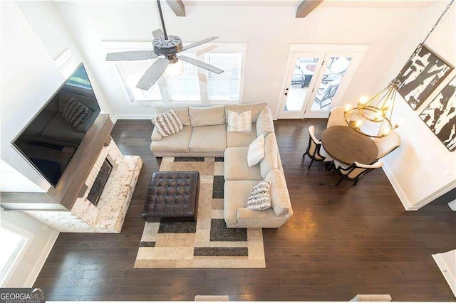living area with dark wood-style floors, beamed ceiling, baseboards, and a ceiling fan
