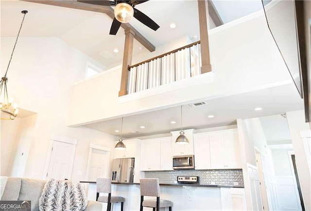 kitchen with tasteful backsplash, a ceiling fan, dark countertops, white cabinets, and appliances with stainless steel finishes