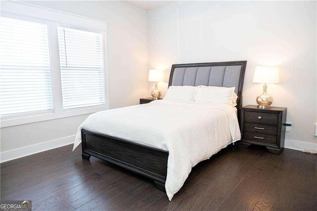 bedroom featuring dark wood-style flooring and baseboards
