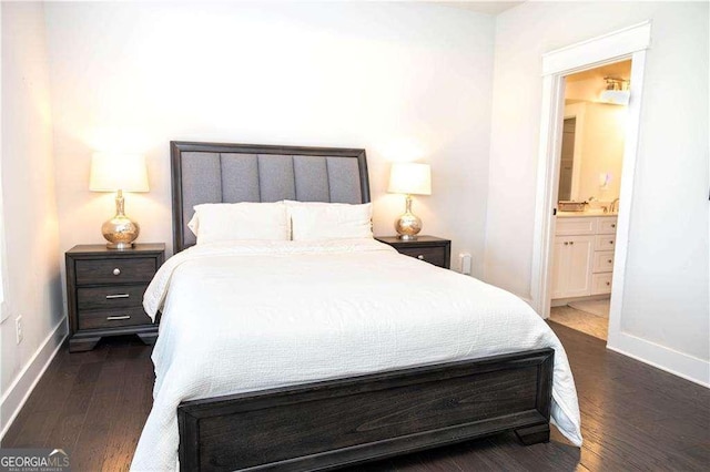 bedroom with ensuite bathroom, baseboards, and wood finished floors
