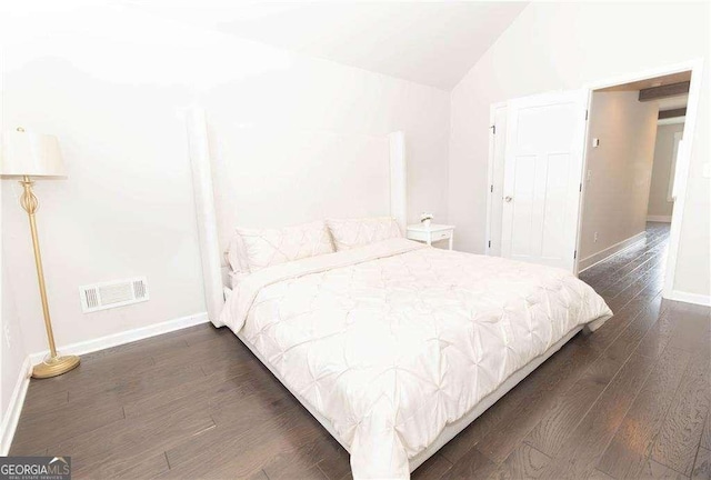 bedroom with dark wood-style flooring, baseboards, vaulted ceiling, and visible vents