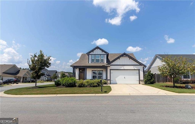 view of front facade featuring a front lawn, fence, a garage, and driveway