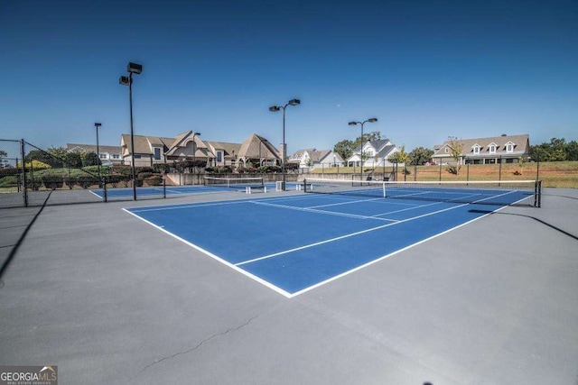 view of sport court with a residential view and fence