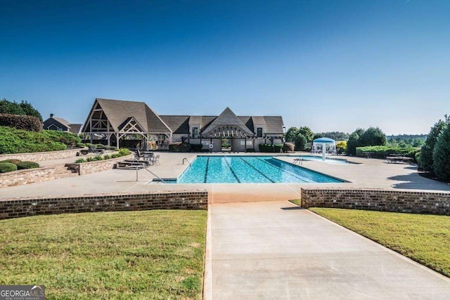 pool featuring a patio area and a yard