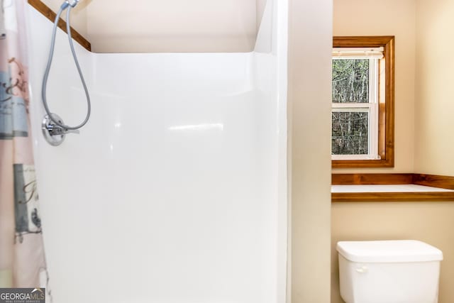 bathroom featuring a shower and toilet