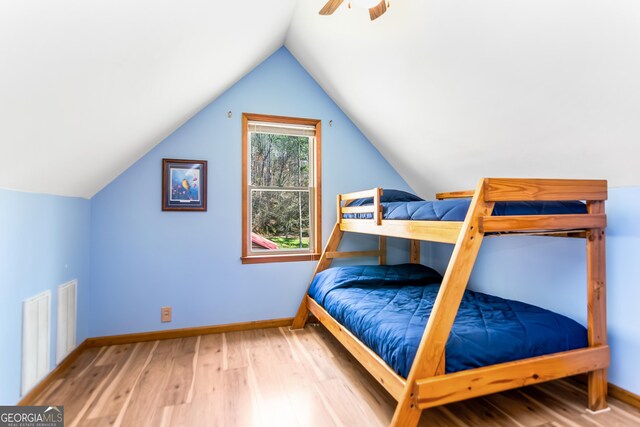 bedroom featuring wood finished floors, baseboards, a ceiling fan, and lofted ceiling