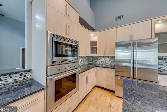 1762 Green Rd, Buford, GA 30518 - kitchen with tasteful backsplash, dark stone countertops, glass insert cabinets, visible vents, and appliances with stainless steel finishes