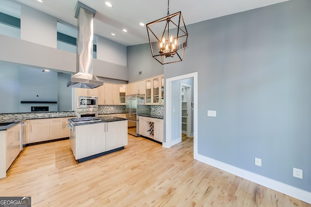 1762 Green Rd, Buford, GA 30518 - kitchen featuring glass insert cabinets, tasteful backsplash, a center island, appliances with stainless steel finishes, and light wood finished floors