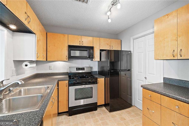 kitchen with black appliances, a sink, dark countertops, and a textured ceiling
