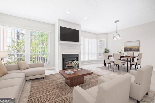 living room featuring healthy amount of natural light, baseboards, a fireplace, recessed lighting, and light carpet