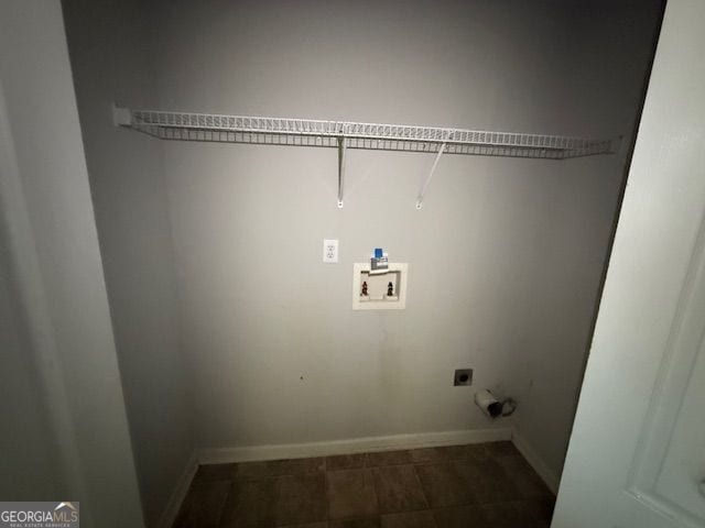 laundry room with hookup for an electric dryer, dark tile patterned floors, baseboards, laundry area, and hookup for a washing machine