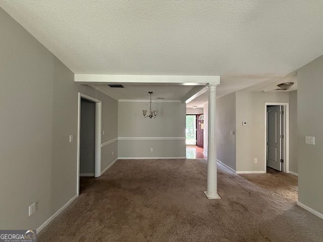 interior space featuring visible vents, ornate columns, carpet floors, and a textured ceiling