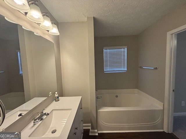 7455 Royal Ct, Riverdale, GA 30296 - bathroom featuring vanity, a textured ceiling, and a garden tub