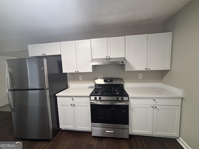 7455 Royal Ct, Riverdale, GA 30296 - kitchen featuring white cabinetry, light countertops, under cabinet range hood, dark wood-type flooring, and appliances with stainless steel finishes