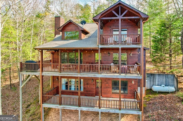 425 Rhonda Ln, Mineral Bluff, GA 30559 - view of front of property with a balcony, a chimney, a shingled roof, and a wooded view