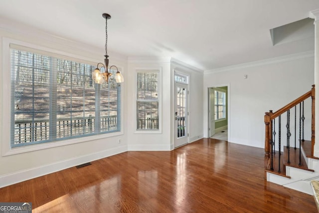 5615 Toccoa Dr, Douglasville, GA 30135 - unfurnished dining area with an inviting chandelier, ornamental molding, wood finished floors, stairs, and baseboards