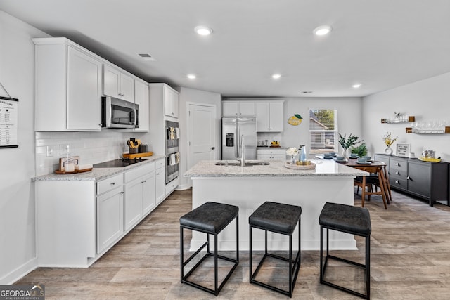 219 Rusty Plow Ln Unit 69, Perry, GA 31069 - kitchen featuring visible vents, white cabinets, a kitchen bar, and stainless steel appliances