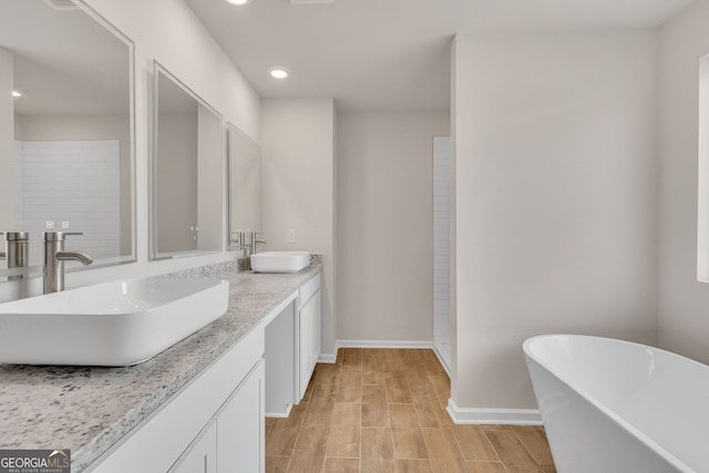 219 Rusty Plow Ln Unit 69, Perry, GA 31069 - bathroom featuring a freestanding tub, baseboards, a sink, and wood finish floors